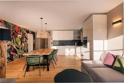 a kitchen and living room with a table and chairs at The Nest – 85 qm apartment - Mountain, Ski, Relax in Vila di Sopra