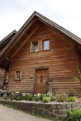 a wooden house with a wooden door and windows at Unterplattnerhof in Chiusa