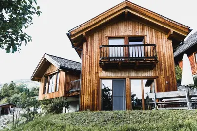 a wooden house with a balcony on a hill at Unterplattnerhof in Chiusa