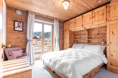 a bedroom with a large bed and a window at ciasa monaco in Corvara in Badia