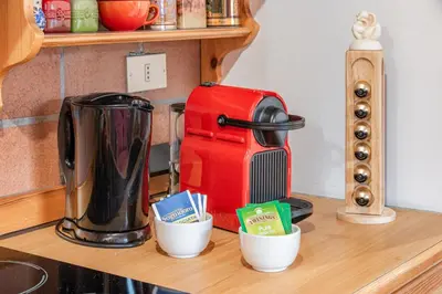 a counter top with a coffee maker and cups on it at ciasa monaco in Corvara in Badia