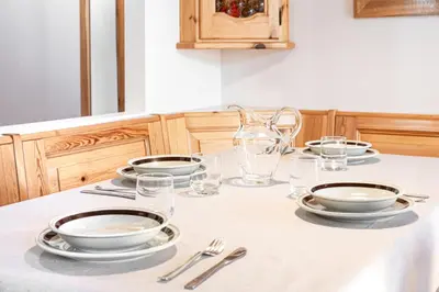 a table with plates and bowls and glasses on it at ciasa monaco in Corvara in Badia