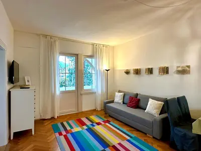 a living room with a couch and a colorful rug at Baker House in Bolzano