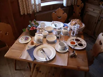 a wooden table with plates and dishes on it at Chalet Resciesa Ortisei in Ortisei