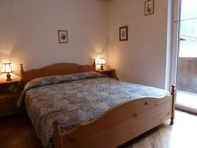 a bedroom with a wooden bed and two lamps at Casa Canazei in Canazei