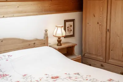 a bedroom with a bed with a lamp on a table at Casa Canazei in Canazei