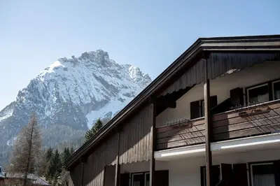 a building with a snow covered mountain in the background at Casa Canazei in Canazei