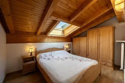 a bedroom with a large bed with a skylight at Casa Canazei in Canazei