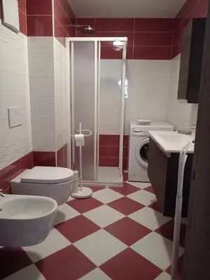 a bathroom with a red and white checkered floor at Ciasa del Faure in Pozza di Fassa