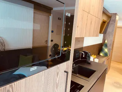 a kitchen with a glass door with a sink at Nuovo e comodo in Val di Fassa in Campitello