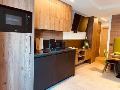 a kitchen with a sink and a microwave at Nuovo e comodo in Val di Fassa in Campitello