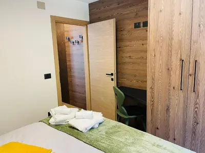 a bedroom with a bed with towels on it at Nuovo e comodo in Val di Fassa in Campitello