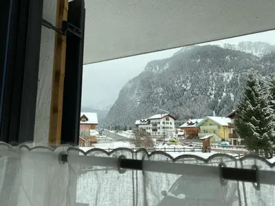 a view of a snowy mountain from a window at Nuovo e comodo in Val di Fassa in Campitello