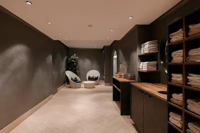 a hallway with two chairs and a room with towels at Hotel Cristallo in Santa Cristina in Val Gardena
