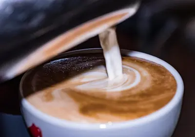 a cup of coffee with a spoon in it at Hotel Cristallo in Santa Cristina in Val Gardena