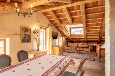 a dining room with a table and a couch at CORTINA Lodge in Cortina dʼAmpezzo