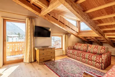 a living room with a couch and a flat screen tv at CORTINA Lodge in Cortina dʼAmpezzo