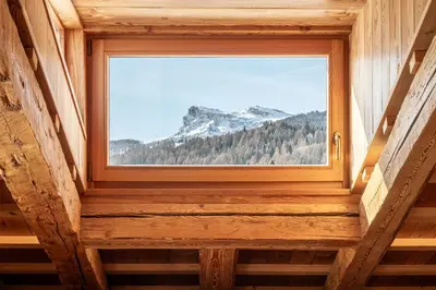a window in a cabin with a view of a mountain at CORTINA Lodge in Cortina dʼAmpezzo