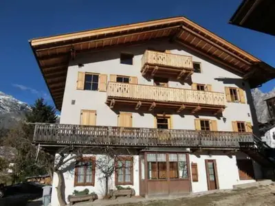 a large building with a balcony on top of it at CORTINA Lodge in Cortina dʼAmpezzo