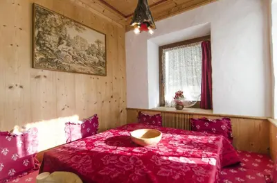 a bedroom with a red bed and a window at Villa Lucente in Alvera