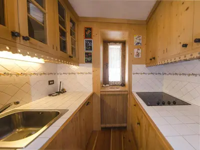 a kitchen with wooden cabinets and a sink and a window at Villa Lucente in Alvera