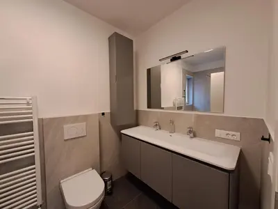 a bathroom with a sink and a toilet and a mirror at Guesthouse Le Palme in Postal