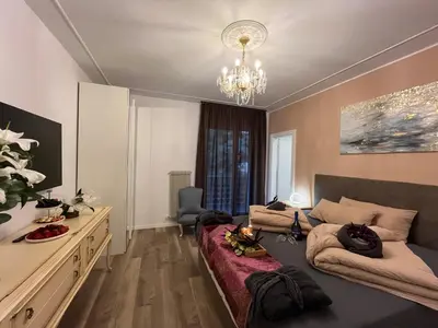 a living room with a bed and a chandelier at Guesthouse Le Palme in Postal