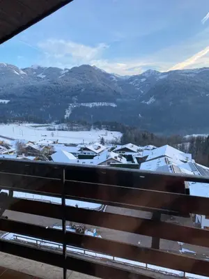 a view from a balcony of a town with snow covered mountains at Affittacamere Garden Cavalese in Cavalese