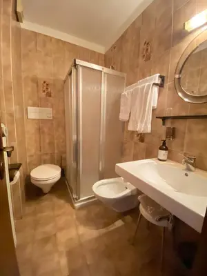 a bathroom with a toilet and a sink and a shower at Affittacamere Garden Cavalese in Cavalese