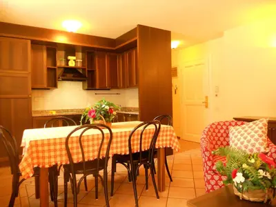 a kitchen with a table and some chairs and a table and a room at Residence Villa Avisio in Canazei