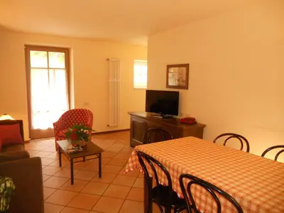a living room with a table and a television at Residence Villa Avisio in Canazei