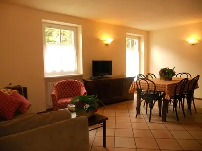 a living room with a table and chairs at Residence Villa Avisio in Canazei