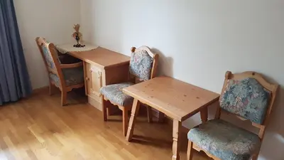 a wooden table with two chairs and a table and a table and chairs at Feldlechn in Lappago