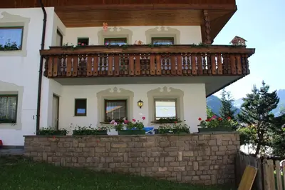 a house with a balcony on top of a brick wall at Feldlechn in Lappago