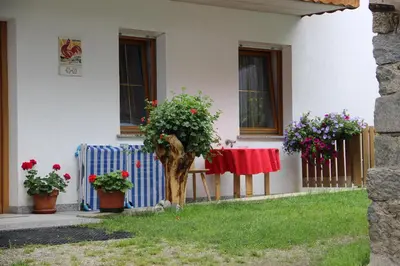 a house with a table and flowers in the yard at Lenzerhof in Lappago