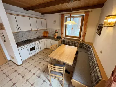 a small kitchen with a wooden table and chairs at Lenzerhof in Lappago