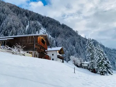 a building on a snow covered hill with trees at Felda Appartements in Lappago