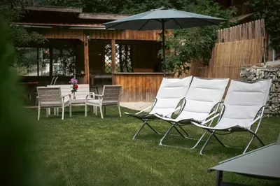 a group of chairs and an umbrella in a yard at Felda Appartements in Lappago