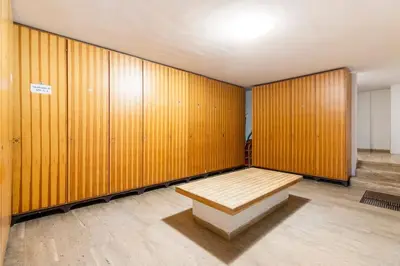 a locker room with a wooden wall with a bench at Dolomiti Haus - Immerso nelle Dolomiti in Tesero