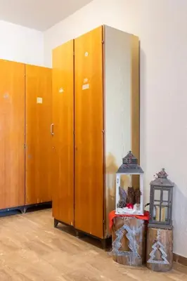 a row of wooden lockers in a room with a lantern at Dolomiti Haus - Immerso nelle Dolomiti in Tesero