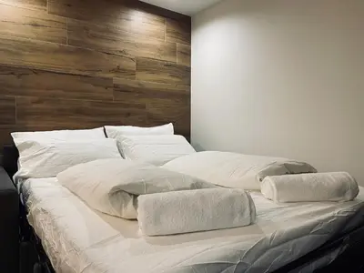 a large white bed with two pillows on it at Dolomiti Haus - Immerso nelle Dolomiti in Tesero