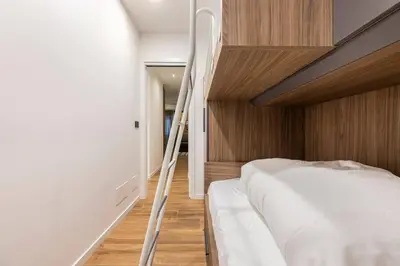 a bedroom with a bunk bed with a ladder at Dolomiti Haus - Immerso nelle Dolomiti in Tesero