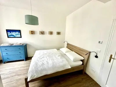 a bedroom with a bed and a blue dresser at Townhouse Bozen in Bolzano