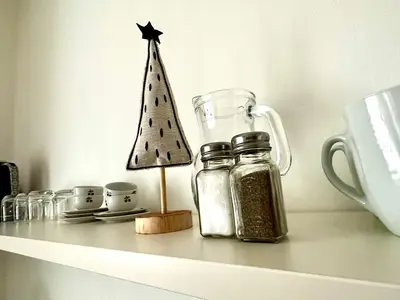 a shelf with a miniature christmas tree and a jar at Townhouse Bozen in Bolzano