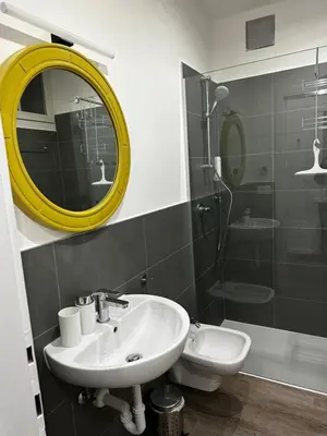 a bathroom with a sink and a mirror and a shower at Townhouse Bozen in Bolzano