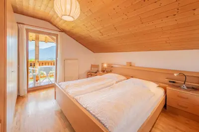 a bedroom with a large bed and a window at Gfillhof Ferienwohnung 2 in Appiano sulla Strada del Vino