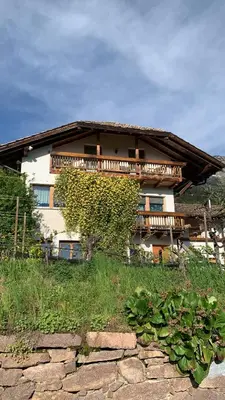 a house on a hill with a stone path in front at Gfillhof Ferienwohnung 2 in Appiano sulla Strada del Vino