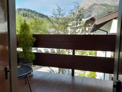 a balcony with a bench and a view of a mountain at Fradusta 213 in San Martino di Castrozza