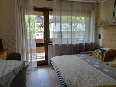 a bedroom with a bed and a large window at Fradusta 213 in San Martino di Castrozza