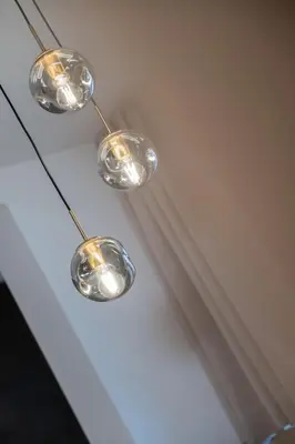 a group of three lights hanging from a ceiling at Apartments Corcela in San Vigilio Di Marebbe